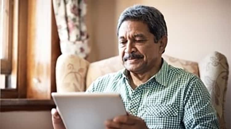 Man at home using Synzi app on his tablet