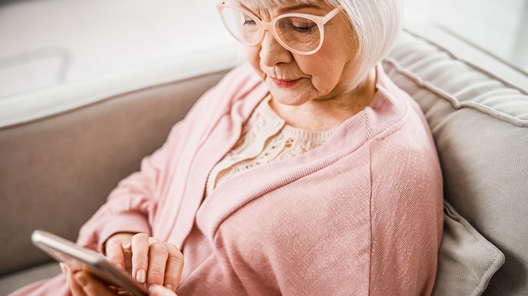 Close up of senior lady checking messages on cellphone stock photo